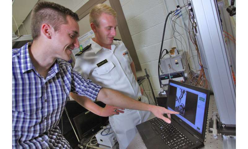 Graduate researcher Taylor Allred and United States Naval Academy Midshipman Nicholas Stovall-Kurtz observe boiling from a water-repellent surface that could help prevent high-powered electronics from overheating. Credit: Purdue University image/Jared Pike Water-repellent surfaces can efficiently boil water, keep electronics cool